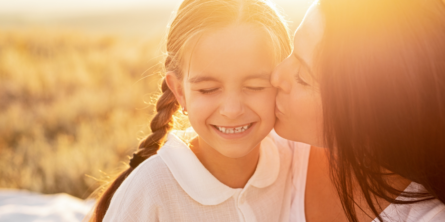 Woman kissing little girl on the cheek