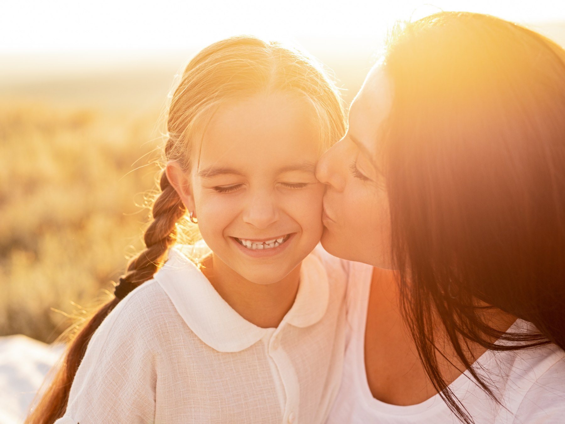 Woman kissing little girl on the cheek